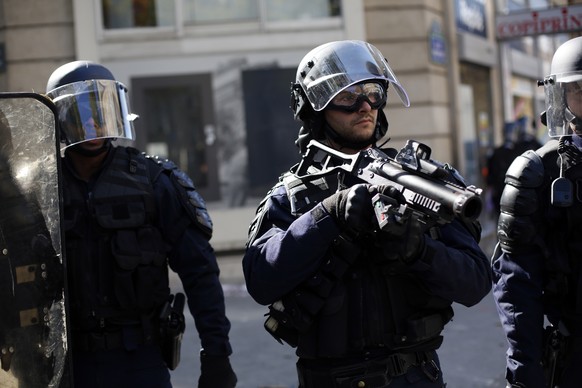 A riot police officer holds a flash ball gun during a climate demonstration, in Paris, Saturday, Sept. 21, 2019. Scuffles broke out in Paris between some violent activists and police which responded w ...