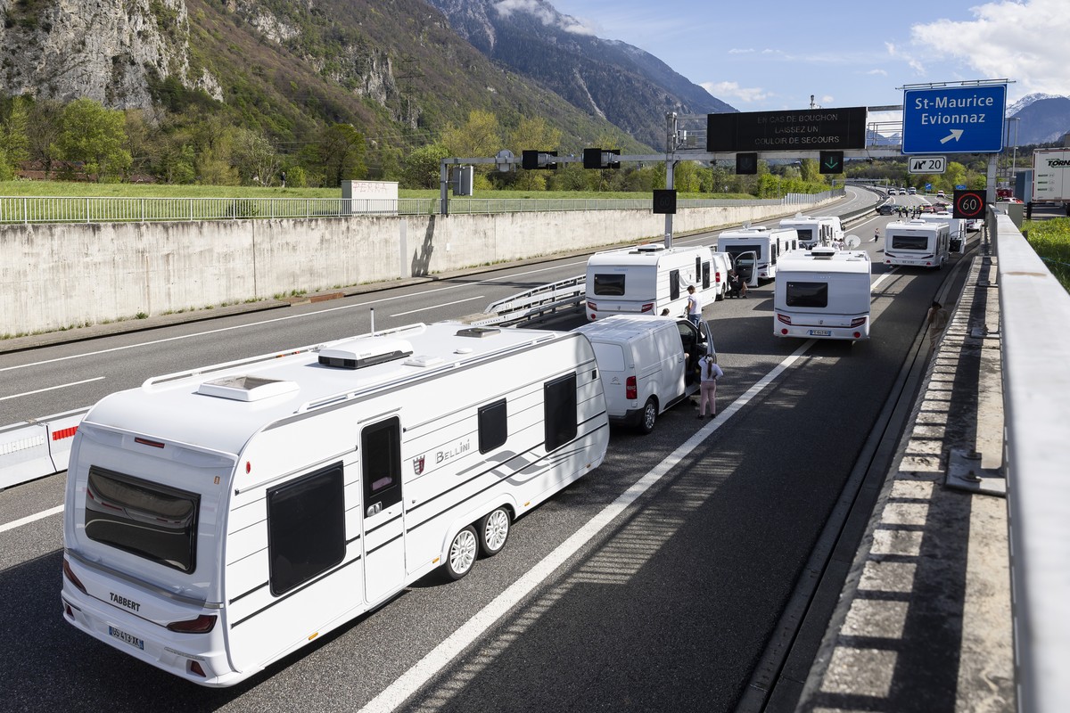 Les membres de la police cantonale valaisanne bloquent un convoi d'une quarantaine de caravanes de gens du voyage sur l'autoroute A9 le mardi 15 avril 2025 a St-Maurice en Valais. (KEYSTONE/ ...