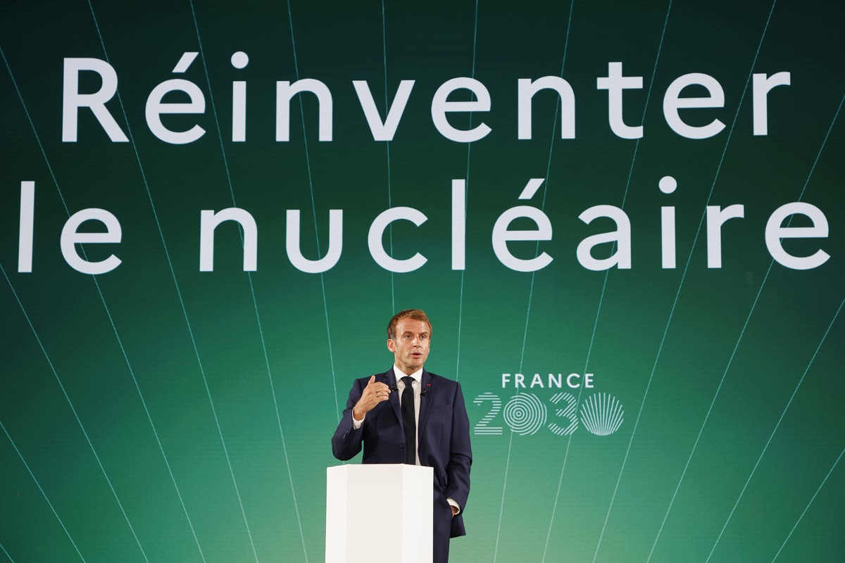 epa09519664 France's President Emmanuel Macron speaks in front of a screen with the sentence reading "Reinvent the nuclear" during the presentation of "France 2030" investment ...