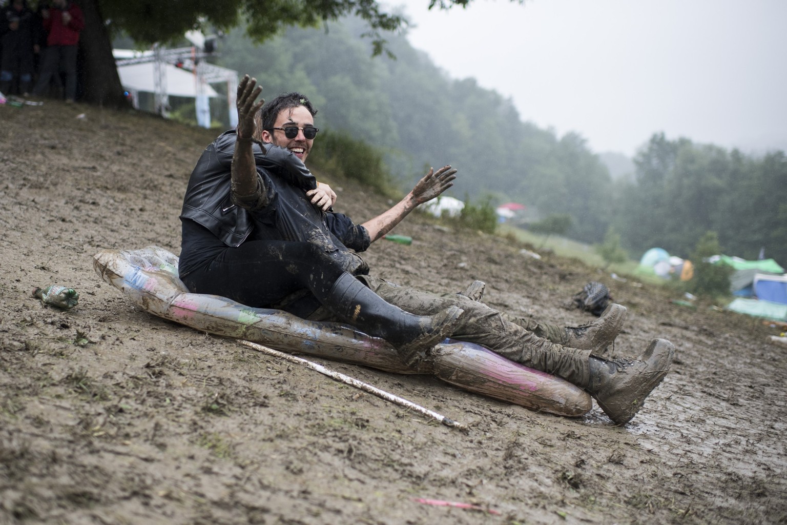 Visitors play in the mud during the music festival Openair St. Gallen, on Sunday, July 2, 2017. The festival will take place until Sunday, July 2, 2017. (KEYSTONE/Ennio Leanza)