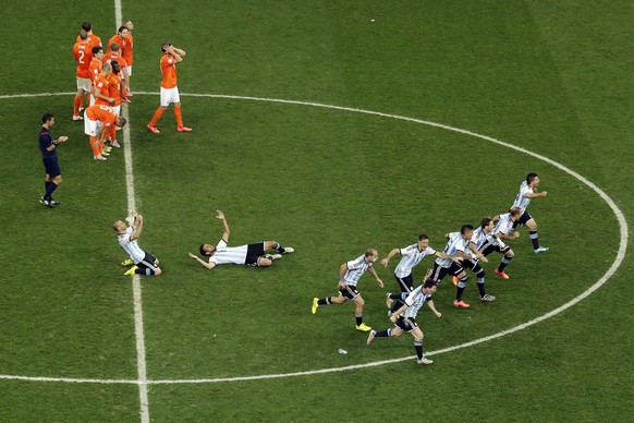 Argentina&#039;s players run to celebrate after teammate Maxi Rodriguez scored the last penalty as Netherlands&#039; players react at the end of the World Cup semifinal soccer match between the Nether ...