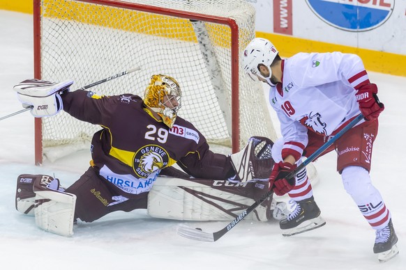 Le joueur du club lausannois, Josh Jooris, droite, a la lutte pour le puck avec le gardien du club genevois, Robert Mayer, gauche, lors du match du championnat suisse de hockey sur glace de National L ...