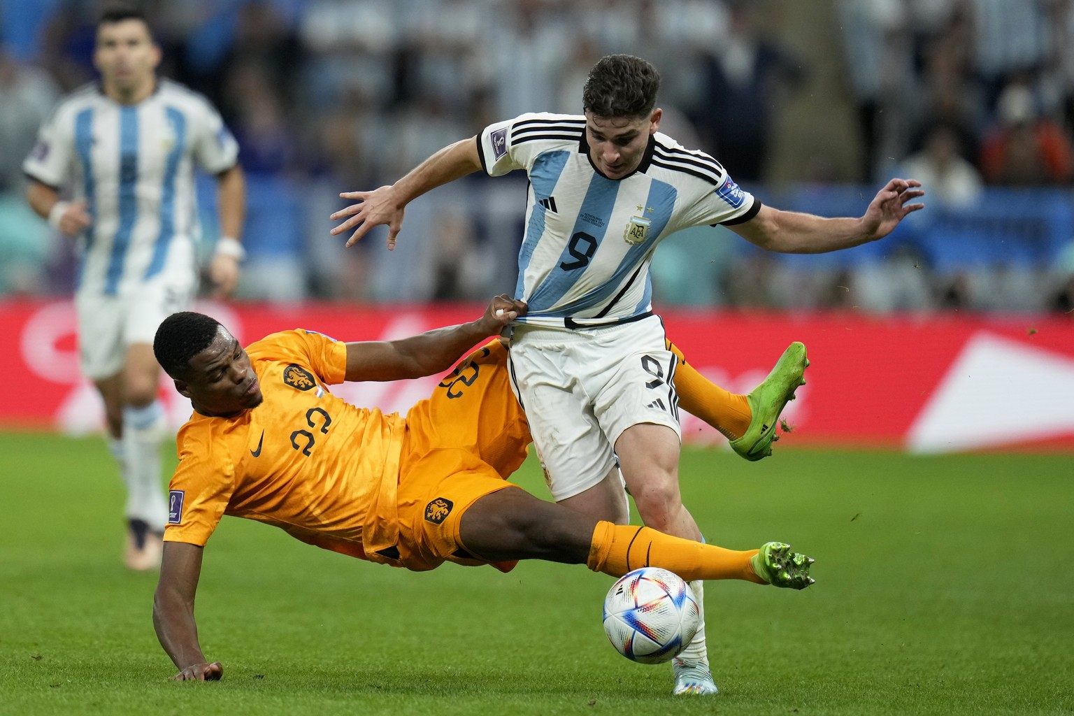 Denzel Dumfries of the Netherlands tries to tackle Argentina&#039;s Julian Alvarez, right, during the World Cup quarterfinal soccer match between the Netherlands and Argentina, at the Lusail Stadium i ...