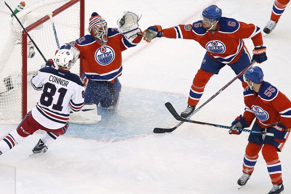 Edmonton Oilers&#039; Adam Larsson (6) attempts to knock down the puck in front of goaltender Cam Talbot (33) as Winnipeg Jets&#039; Kyle Connor (81) attacks and Oilers&#039; Mark Letestu (55) defends ...