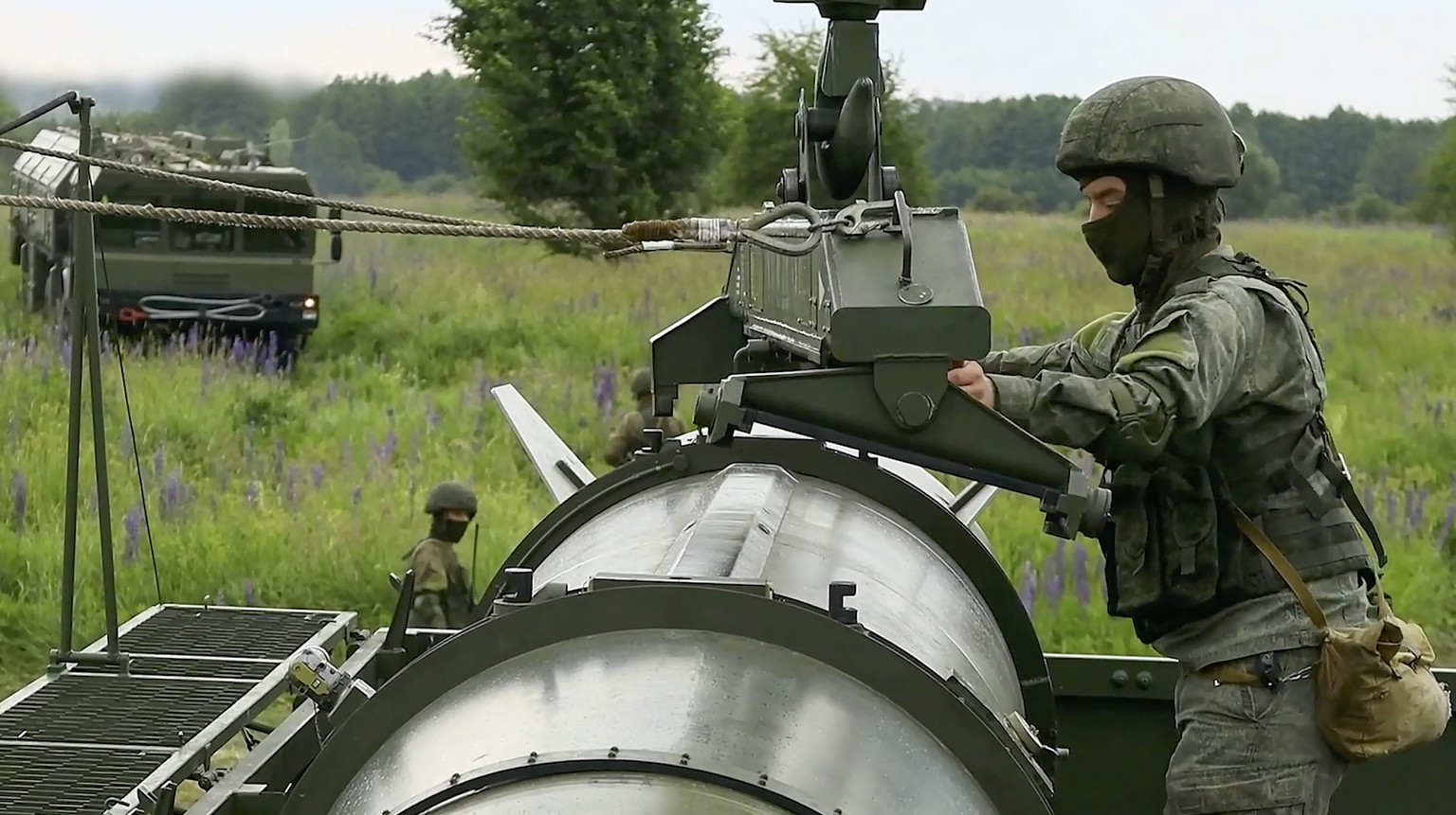epa11407646 A still image taken from a handout video made available by the Russian Defence Ministry press-service shows Russian servicemen operating a non-strategic nuclear missile for Iskander operat ...