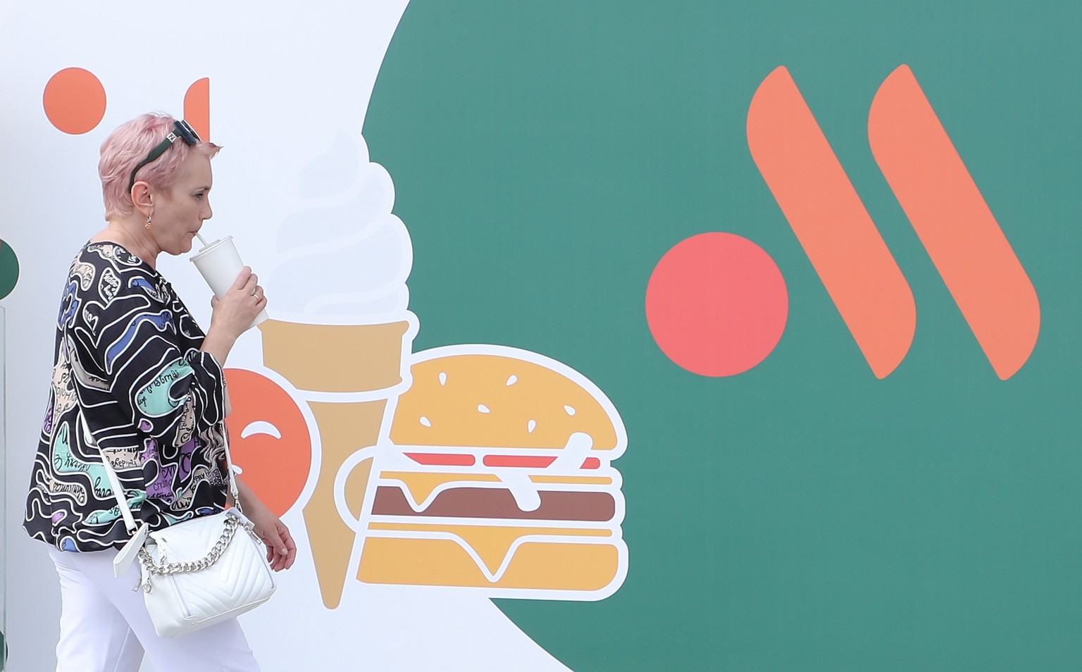 epaselect epa10009475 A woman passes by a former McDonald&#039;s restaurant during reopening under a new brand Vkusno I Tochka in Moscow, Russia, 12 June 2022. On 14 March 2022, due to events in Ukrai ...