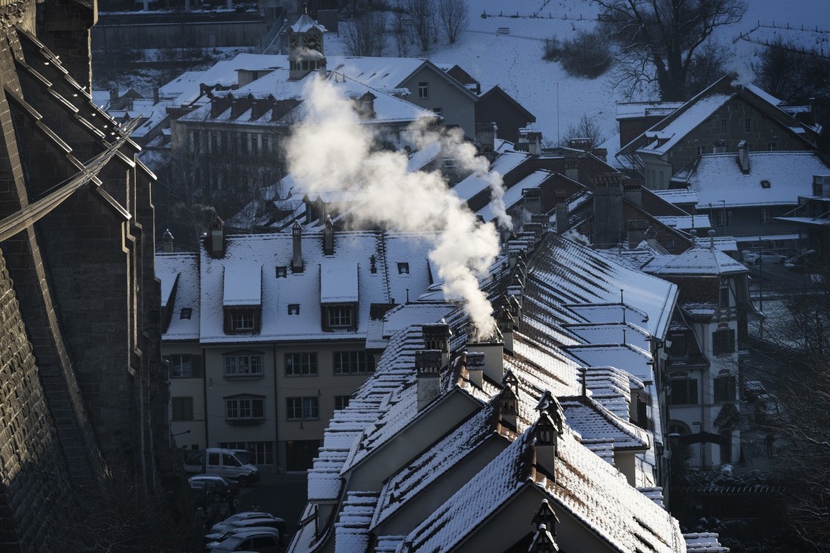 Die Rauchsaeulen von Kaminen im Morgendlichen Gegenlicht, fotografiert am Donnerstag, 19. Januar 2023 in Bern. (KEYSTONE/Christian Beutler)