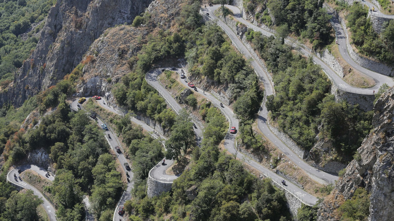 Riders, team cars and press motorcycles climb the harpins of Montvernier during the eighteenth stage of the Tour de France cycling race over 186.5 kilometers (115.9 miles) with start in Gap and finish ...