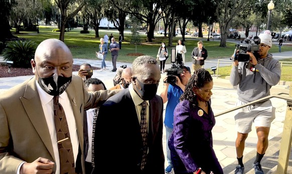 Ahmaud Arbery&#039;s father Marcus Arbery, center, heads into the Glynn County Courthouse in Brunswick, Ga with his attorney Benjamin Crump on Monday, Oct. 18, 2021. Jury selection got underway with h ...