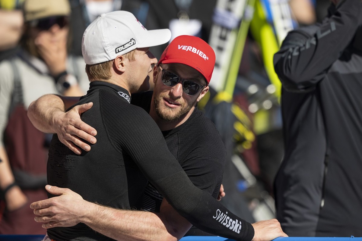 Justin Murisier of Switzerland, right, hugs Marco Odermatt of Switzerland in the finish area during the men's super-g race at the FIS Alpine Skiing World Cup finals in El Tarter, Andorra, Thursda ...