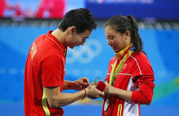 epa05485049 He Zi (R) of China receives a marriage proposal from Chinese diver Ki Qin (L) after winning the silver medal in the women&#039;s 3m Springboard final of the Rio 2016 Olympic Games Diving e ...