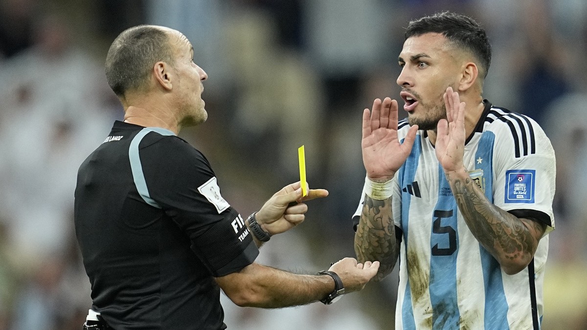 Referee Antonio Mateu shows a yellow card to Argentina's Leandro Paredes during the World Cup quarterfinal soccer match between the Netherlands and Argentina, at the Lusail Stadium in Lusail, Qat ...