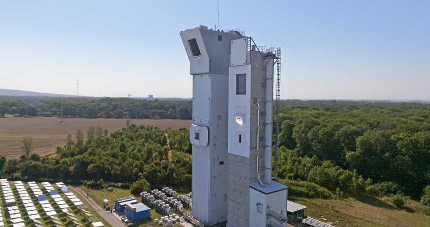 Das Spiegelfeld bündelt die Sonnenstrahlung auf den DLR-Multifokus-Solarturm (rechts), wo der Sonnenempfänger von Synhelion hell erleuchtet ist.