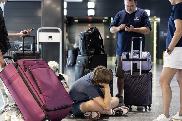 epa11487348 A family from Boston, US, wait to catch their flight home, at the Zurich Airport in Kloten, Switzerland, 19 July 2024. Due to a major worldwide IT outage, check-in for air travelers and fl ...