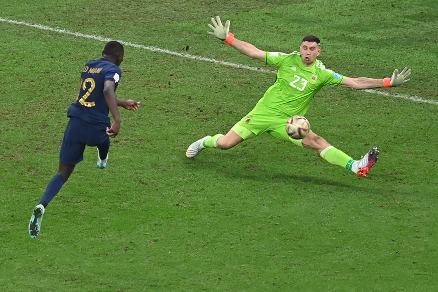 epa10372782 Goalkeeper Emiliano Martinez of Argentina saves a shot from Randal Kolo Muani (L) of France in the dying moments of the FIFA World Cup 2022 Final between Argentina and France at Lusail sta ...