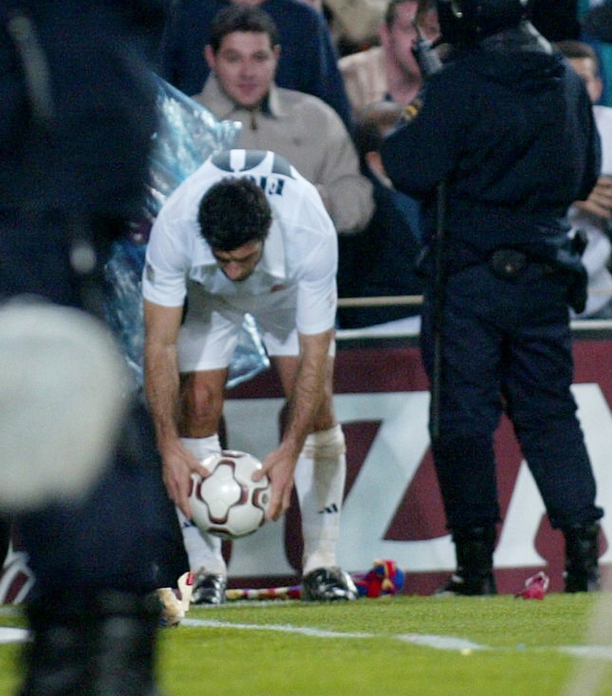 Real Madrid's Portugues player Luis Figo is protected by police as he takes a corner during a Spanish league soccer match against his old club Barcelona in Barcelona Saturday Nov 23, 2002. Figo w ...