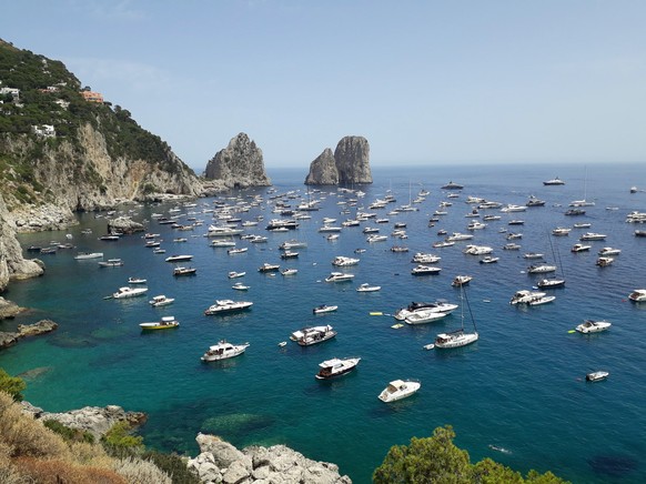 epa09305680 The stretch of sea in front of the Faraglioni crowded with boats, Capri island, southern Italy, 27 June 2021. High temperatures are expected in the country for the whole of next week. EPA/ ...