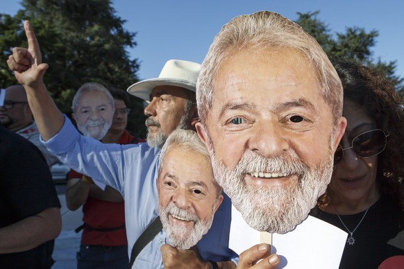 epa06951664 Brazilians living in Switzerland hold portraits of former Brazilian President Luiz Inacio Lula da Silva, during a rally on the occasion of filing Lula&#039;s candidature to Brazilian presi ...