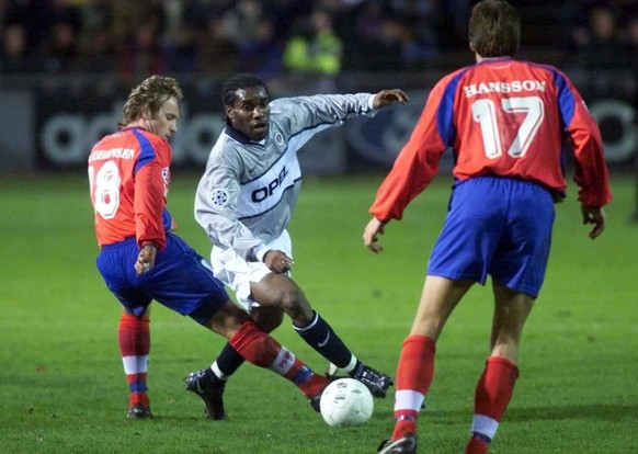 Jay-Jay Okocha, center, of Paris Saint-Germain tries to dribble past Stig Johansen, left, and Mikael Hansson, right, of Helsingborg during the Champions League, Group F, soccer game in Helsingborg, Sw ...