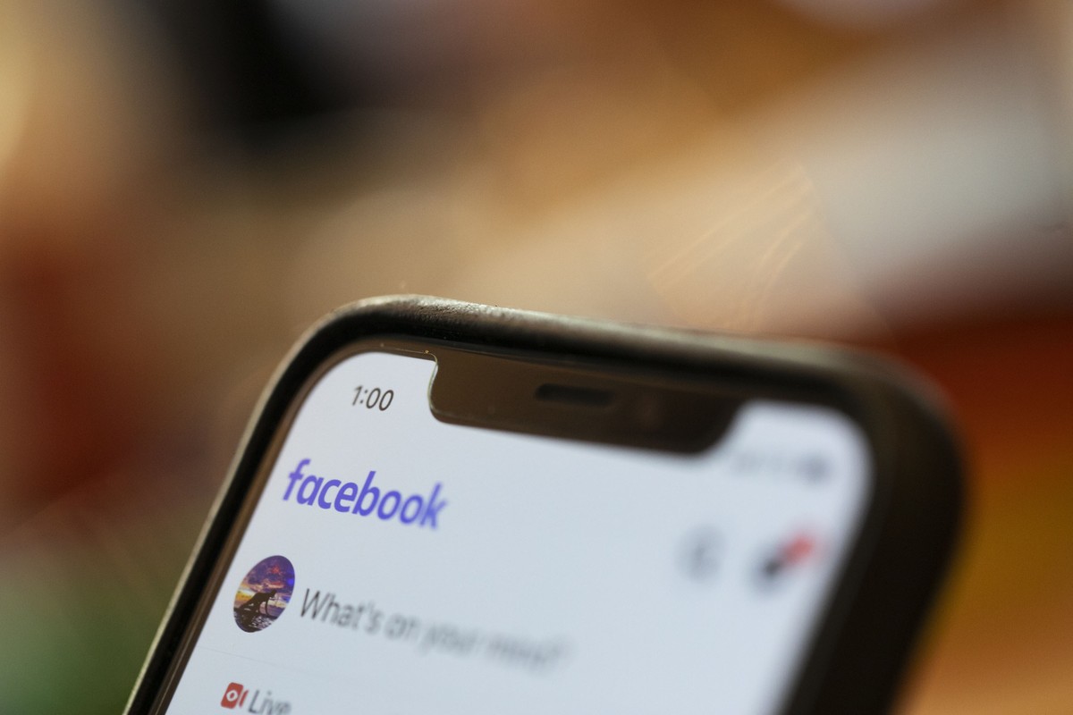FILE - In this Aug. 11, 2019, file photo an iPhone displays a Facebook page in New Orleans. Facebook says hackers in China used fake accounts and impostor websites in a bid to break into the phones of ...