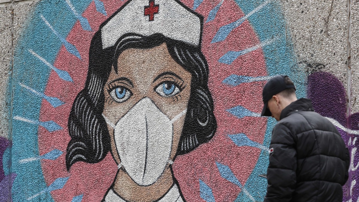 A man passes a graffiti by street artist 'Uzey', depicting a nurse as superhero in the coronavirus pandemic on a wall in Hamm, Germany, Monday, Sept. 28, 2020. The city of Hamm is the number ...