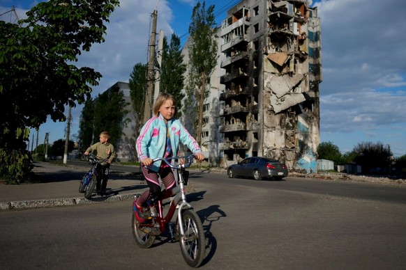 Das Bild zeigt ein Mädchen in Borodyanka, Ukraine, vor einem Hochhaus, das von Bomben zerstört wurde.