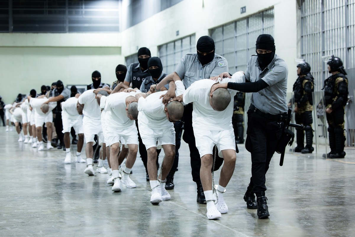 epaselect epa11969342 A handout photo made available by the Presidency of El Salvador shows guards at the Terrorism Confinement Center (Cecot) transferring alleged members of the criminal gang known a ...