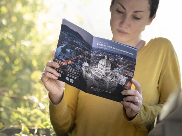 Eine Frau betrachtet das Wahlmaterial fuer die National- und Staenderatswahlen, am Samstag, 7. Oktober 2023, in Lugano. (KEYSTONE/Ti-Press/Pablo Gianinazzi)