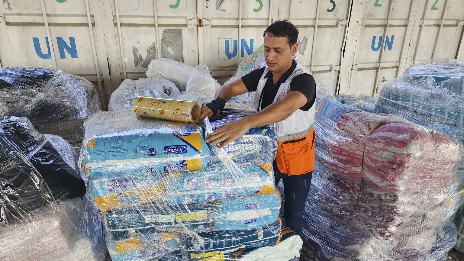United Nations and Red Crescent workers prepare the aid for distribution to Palestinians at UNRWA warehouse in Deir Al-Balah, Gaza Strip, on Monday, Oct. 23, 2023. (AP Photo/Hassan Eslaiah)