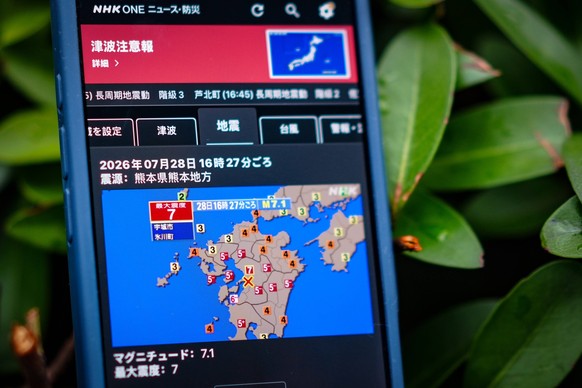 260728 -- TOKYO, July 28, 2026 -- This photo taken on July 28, 2026 in Tokyo, Japan, shows a mobile phone screen displaying the earthquake information. An earthquake with a preliminary magnitude of 7. ...