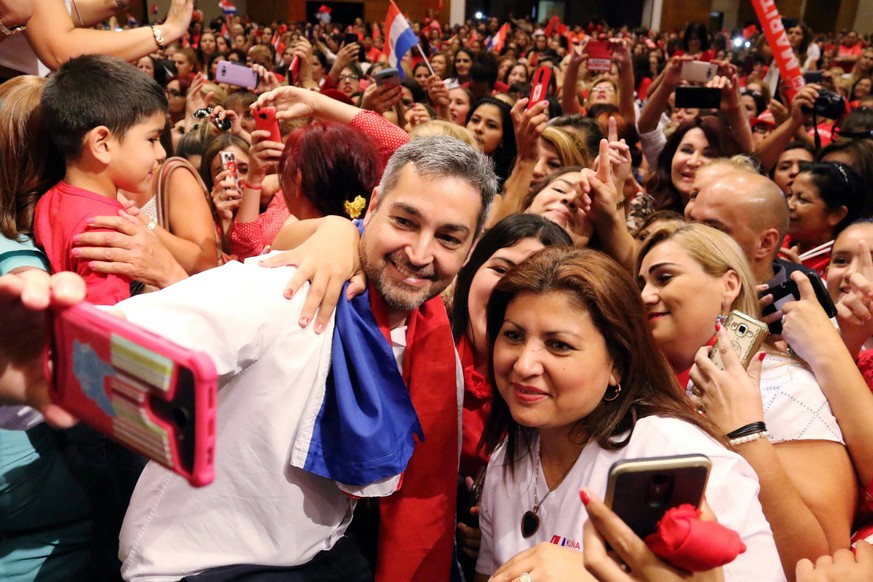 epa06561422 Paraguay presidential candidate for the ruling Colorado Party, Senator Mario Abdo Benitez (C), poses for a photo during a meeting with women at the headquarters of the South American Footb ...