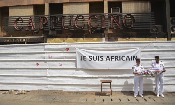 epa05172682 French soldiers hold a wreath during a visit of French Prime Minister Manuel Valls to the site of the January terrorist attacks at Cappuccino bar and the Splendid Hotel in Ouagadougou, Bur ...