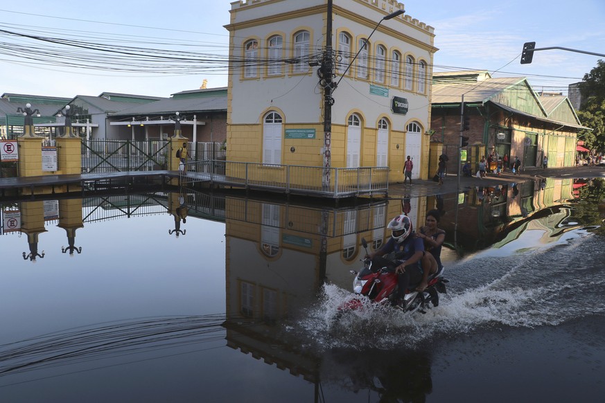 A man rides his motorcycle through a street flooded by the Negro River, in downtown Manaus, Amazonas state, Brazil, Tuesday, June 1, 2021. Rivers around Brazil&#039;s biggest city in the Amazon rain f ...