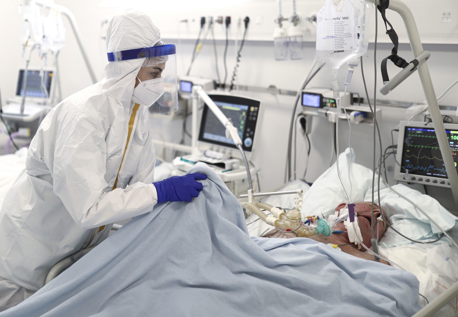 A member of the medical staff attends to a patient at the COVID-19 ICU unit of the Dr. Abdulah Nakas General Hospital in Sarajevo, Bosnia, Friday, Sept. 24, 2021. The COVID-19 rate of infections in Bo ...