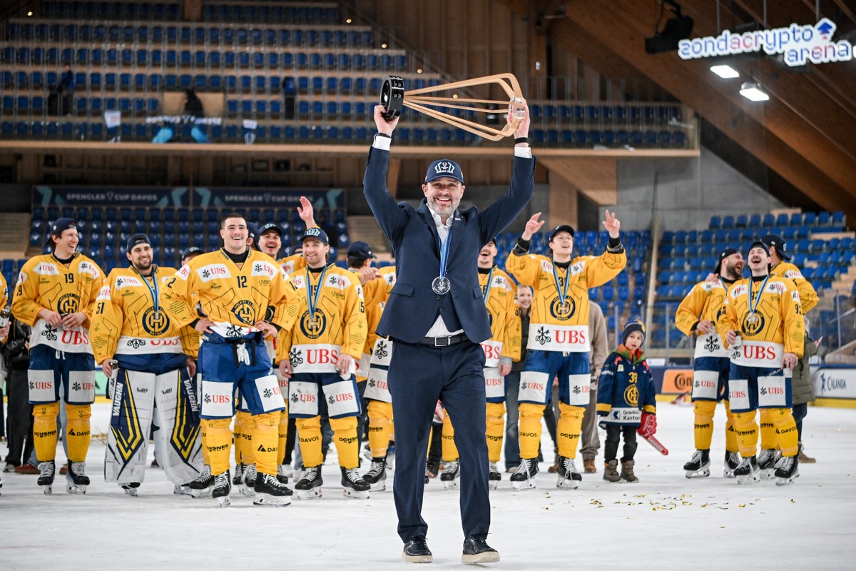 Davos' head coach Josh Holden celebrate with the trophy after winning the final game between US Collegiate Selects and HC Davos of Switzerland at the 97th Spengler Cup ice hockey tournament in Da ...