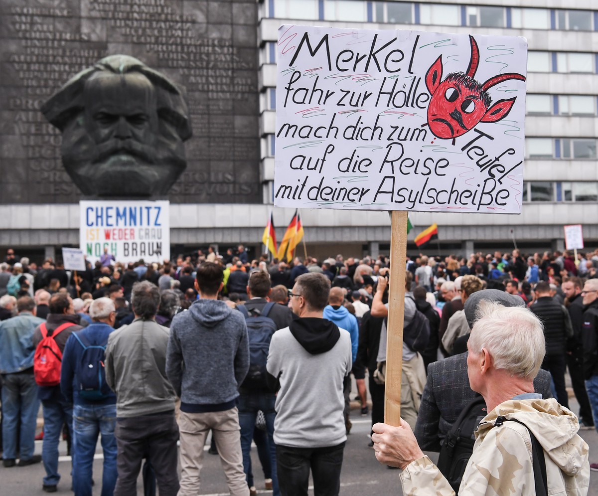 01.09.2018, Sachsen, Chemnitz: Teilnehmer der Kundgebung der rechtspopulistischen Bürgerbewegung Pro Chemnitz versammeln sich vor dem Karl-Marx-Denkmal an dem e
in Plakat mit der Aufschrift «Chemnitz ...