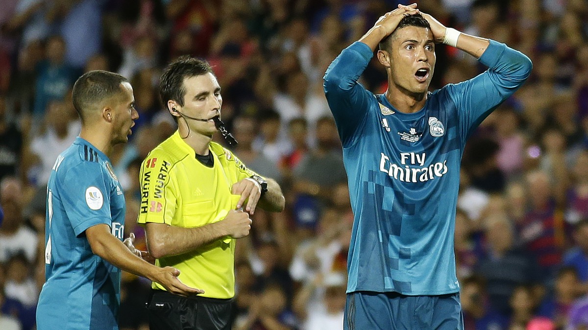 Real Madrid's Cristiano Ronaldo, right, reacts after Referee Ricardo de Burgos shows a yellow card during the Spanish Supercup, first leg, soccer match between FC Barcelona and Real Madrid at the ...