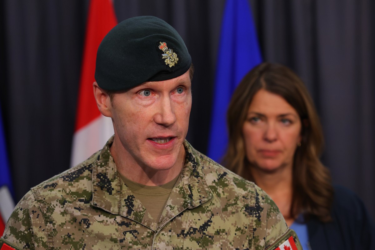 Major-General L.W. Rutland, center, speaks as Alberta Premier Danielle Smith, right, listens during a news conference in Edmonton, Alberta, Sunday, Oct. 18, 2026. (James Maclennan/The Canadian Press v ...