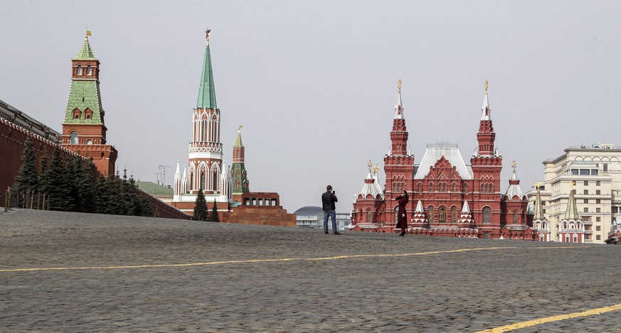 epa08330011 A couple takes pictures on the empty Red Square in Moscow, Russia, 29 March 2020. Russian authorities recommended for all Russians do not leave their homes for nine days in order to stop t ...