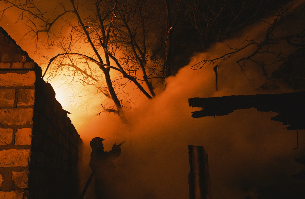 epaselect epa10386755 A rescuer tries to put out a fire of a private building after a Russian shelling in the Ivanivka village near Bakhmut of the Donetsk area, Ukraine, 02 January 2023 amid the Russi ...
