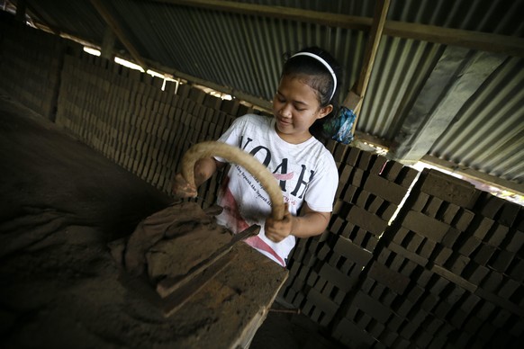 Szene aus Indonesien: Ein Mädchen arbeitet in einer Ziegelfabrik.