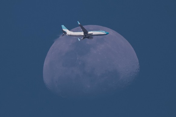 epaselect epa12426392 A plane flies with the moon in the background in Banfield, Argentina, 02 October 2025. EPA/Juan Ignacio Roncoroni