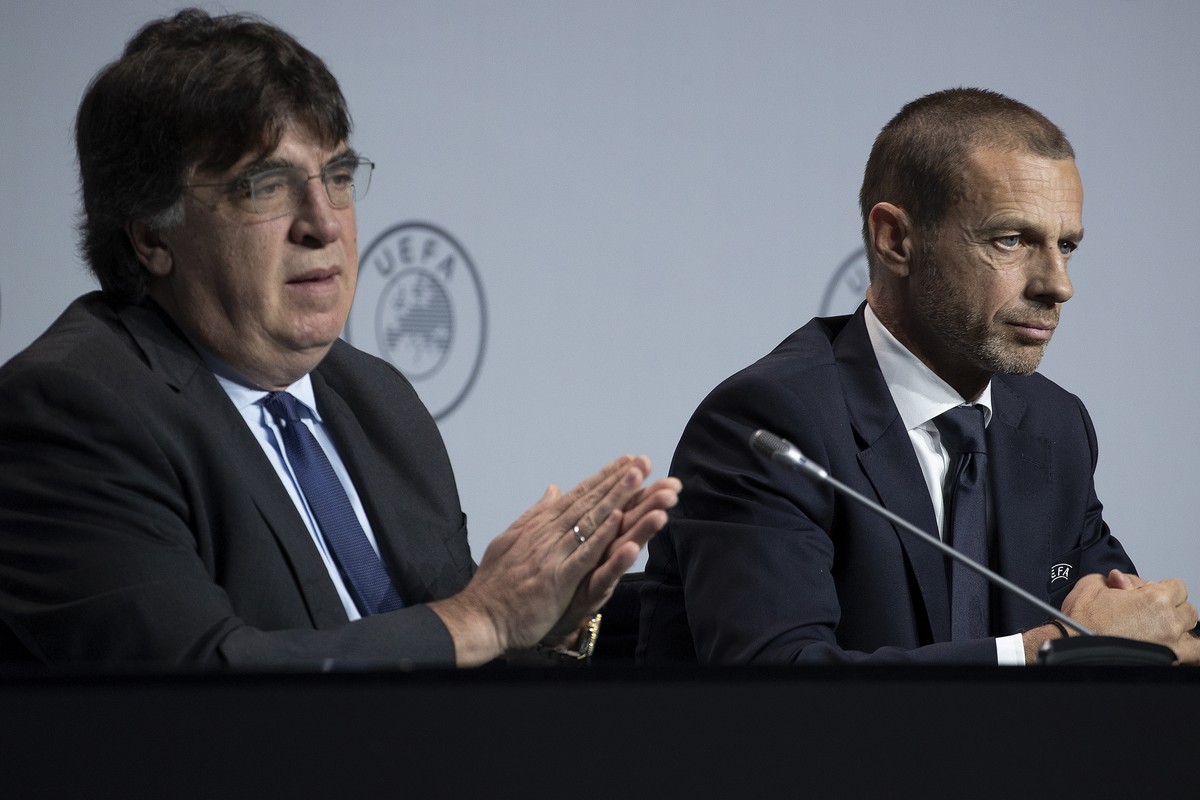 UEFA's Interim General Secretary Theodore Theodoridis, left, washes his hand with a sanitizing gel during a press conference with President Aleksander Ceferin, right, following a meeting of Europ ...