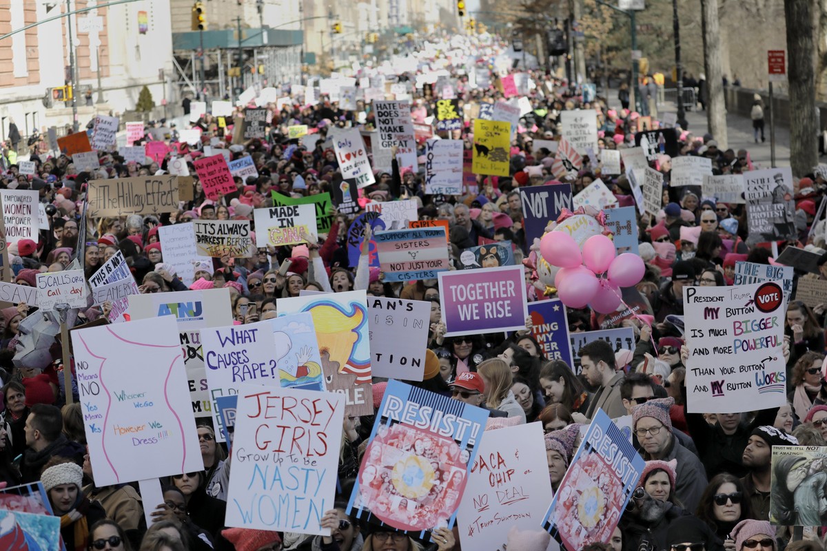 epa06458465 People gather holding protest signs on Central Park West for the 2018 Women's March on NYC, in New York, New York, USA, 20 January 2018. The protest, which is taking place in cities a ...