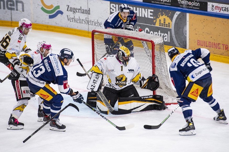 Dario Wuethrich, links, und Jerome bachofner, rechts, von Zug im Spiel gegen Torhueter Tim Wolf, mitte, von Ajoie beim Eishockey Qualifikationsspiel der National League zwischen dem EV Zug und dem HC  ...