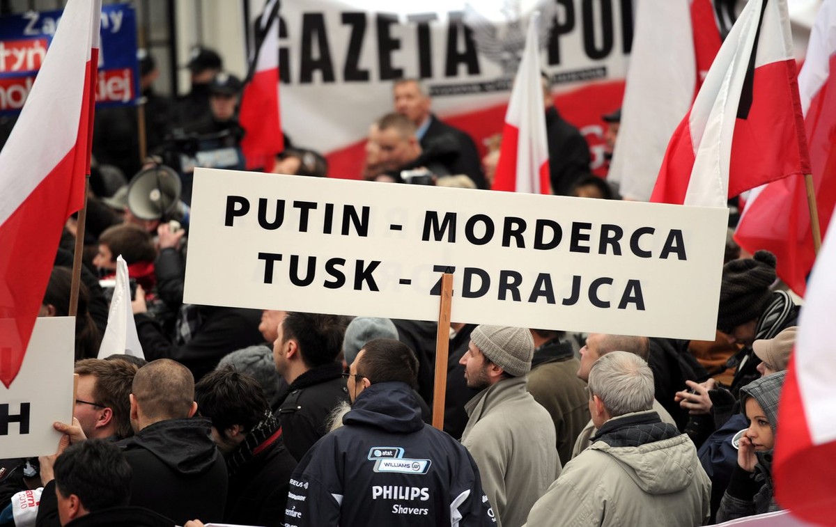 epa02678868 Poles demonstrate holding banner 'PUTIN - MURDERER, TUSK - TRAITOR' in front of the Russian embassy in Warsaw, demanding that Russia give over all the evidence on the reasons beh ...