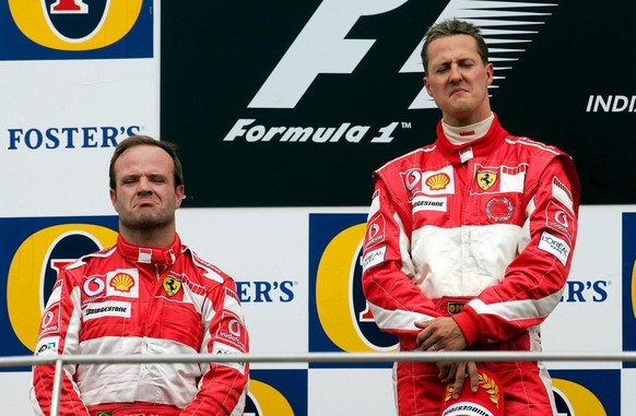 German Formula One driver Michael Schumacher (R) and his Brazilian teammate Rubens Barrichello of Ferrari react on the podium after their victory in the US Grand Prix at race track in Indianapolis, US ...