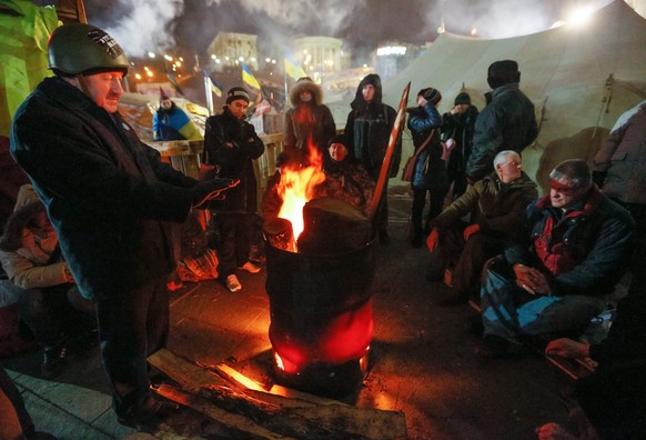 Auch in der Nacht harren die Demonstranten aus und wärmen sich an improvisierten Feuerstellen auf. 