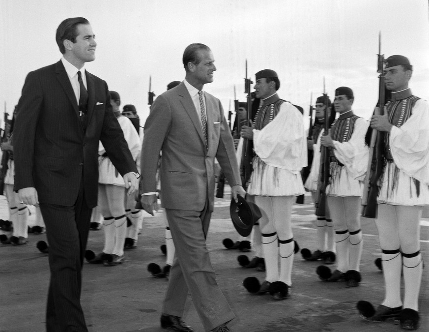 FILE - In this March 25, 1965 file photo, King Constantine II of Greece, left, and Prince Philip of Britain review an honor guard of the Greek Royal Evzones Guard as the prince arrives at the Athens A ...
