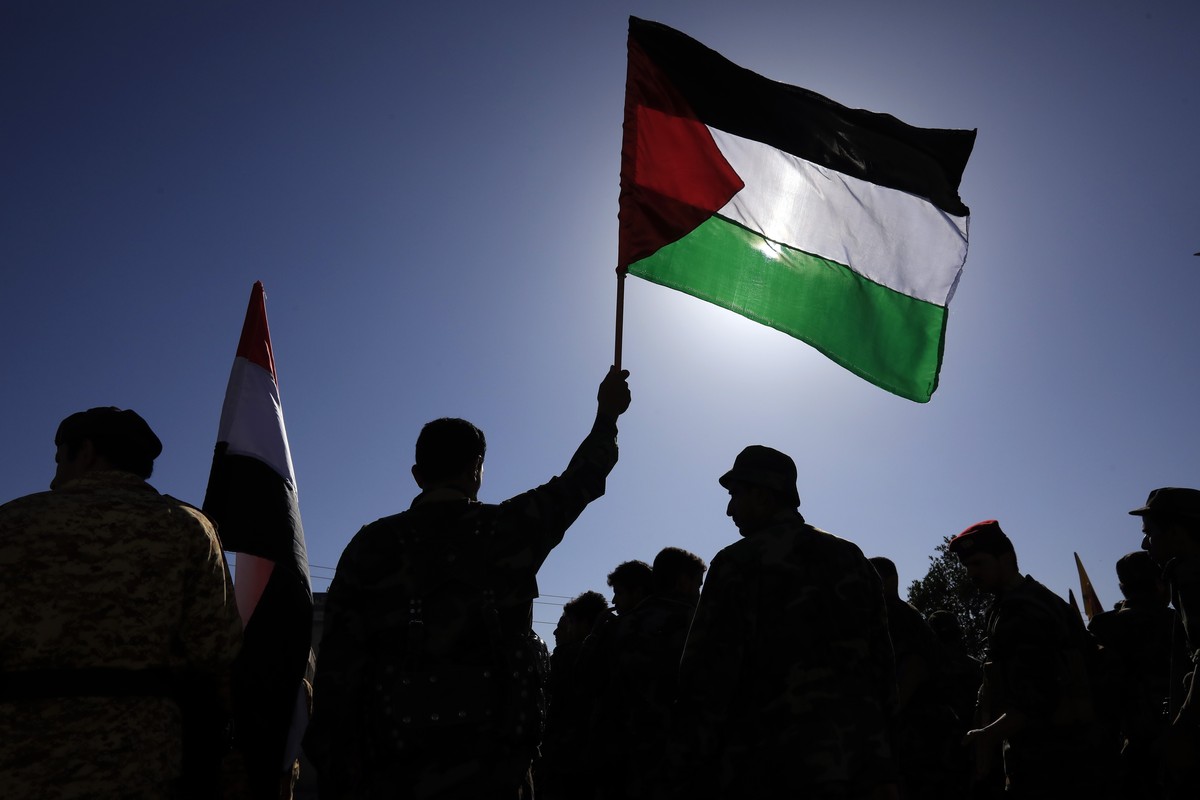 epa10915216 A Houthi fighter holds up a Palestinian flag during a military parade in solidarity with Palestinians in the Gaza Strip, in Sana'a, Yemen, 12 October 2023. The top leader of the Houth ...